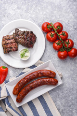 BBQ party with venison grilled meat, grilled käsekrainer (cheese sausages), fresh red sweet paprika and tomatoes