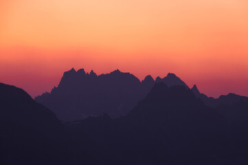 orange colours sunset at the black silhouette mountains