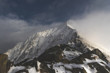 portrait of the mountain. view on the snowy mountain peak with clouds.