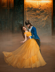 loving couple is dancing at fairy ball. Happy beauty woman fantasy princess in yellow dress and guy...