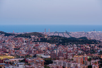 Panoramic view of the city of Barcelona from the viewpoint of L'Arrabassada. During sunset, a spring day. The sky is completely covered with clouds.