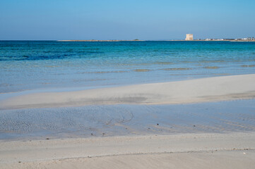 Fototapeta na wymiar Sabbia bianca con mare trasparente e cielo azzurro.