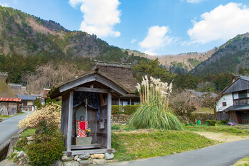 Jizo and an old house with a thatched roof in Kitamura, Miyama Kayabuki no Sato, Nantan City, Kyoto Prefecture, Japan