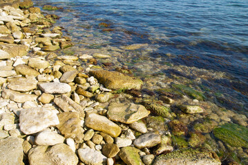 Coast with pebble and blue sea water