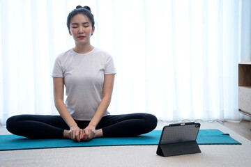 Fototapeta premium Asian woman play yoga on the map in her home