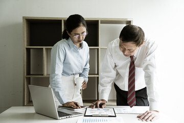 The senior manager are teaching his assistant and listening to a report