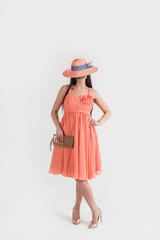 Full-length portrait young elegant woman in color dress and hat. Fashion studio shot in retro style.