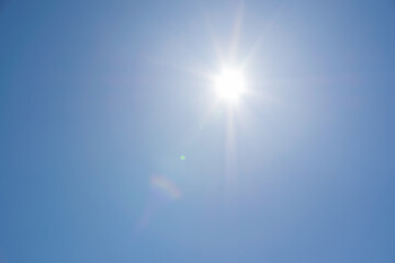 Clear blue sky, sun, beautiful sunbeams and glare