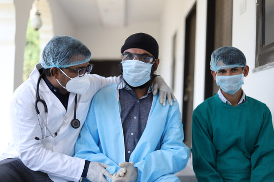 Doctor And His Assistants With Medical Uniform Talking To Each Other Sitting On A Clinic Stairs