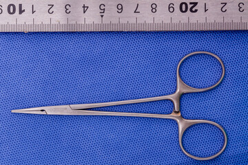 Halsted mosquito forceps on a blue background