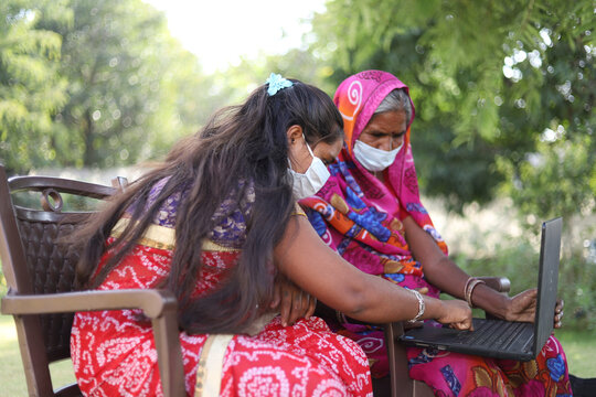 Closeup shot of two Indian women with masks checking statistic of COVID-19