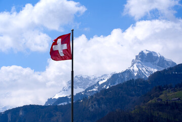 Swiss Flag blowing in the wind. Photo taken April 14th, 2021, Brunnen, Switzerland.
