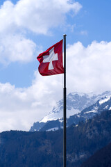 Swiss Flag blowing in the wind. Photo taken April 14th, 2021, Brunnen, Switzerland.