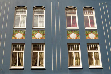 Close-up of eight windows of a beautifully blue painted art nouveau (Jugendstil) house in the city of Alesund, Norway, Europe
