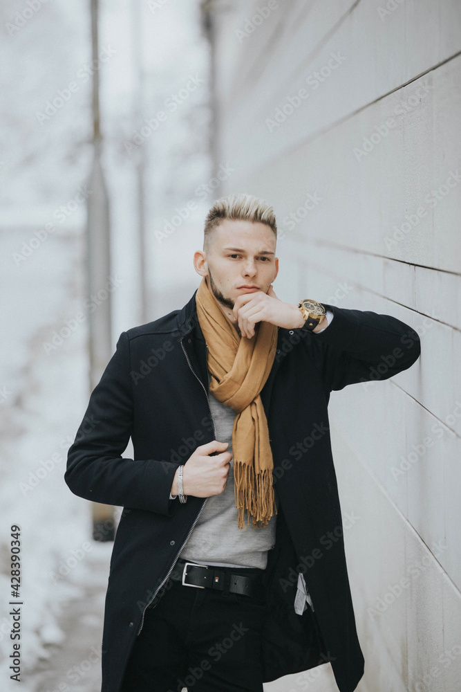 Canvas Prints vertical shot of a caucasian stylish male posing outdoors in a snowy city