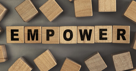 The word EMPOWER on small wooden blocks at the desk. Top view