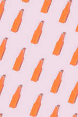 Pattern made with red bottle of cocktails against pastel pink background.Minimal summer concept of sunny day.