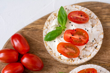 Rice cake sandwich with cheese cream, tomato, basil and spices. A healthy dietary snack