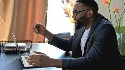 Online video communication. Happy smiling African American guy, business leader or manager, uses laptop for video communication with coworkers, telecommunication concept, chatting via video call