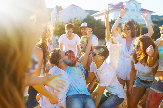 Group of people have fun at the holi festival of colors. Smiling faces in colorful powder. Celebrating traditional indian spring holiday. Party, vacation concept. Friendship and celebration concept.