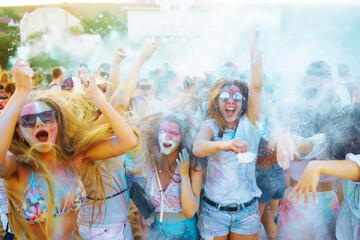 Group of people have fun at the holi festival of colors. Smiling faces in colorful powder. Celebrating traditional indian spring holiday. Party, vacation concept. Friendship and celebration concept.