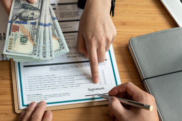 Hands of businessmen agreeing to the offer of bribery by signing a personal benefit agreement The concept of fraud and business practices within the company