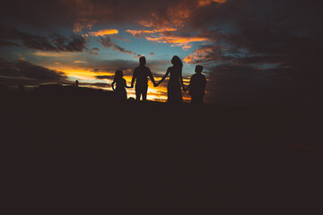 Fototapeta na wymiar parents and children walking at sunset