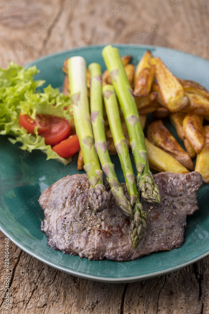 Sticker asparagus on a grilled steak