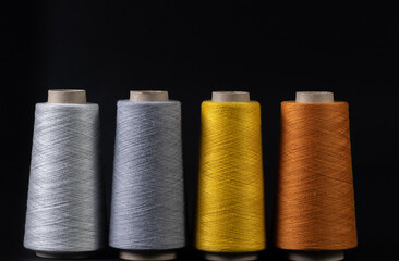 colorful bobbins of thread isolated on black background.