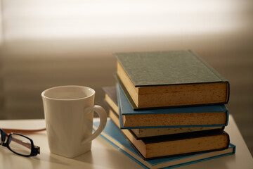 Fototapeta premium stack of book and cup coffee by window ,evening