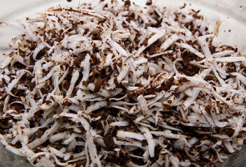 Coconut chips with chocolate grated into a plate.