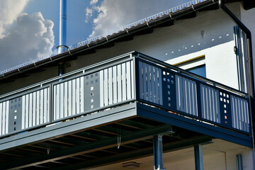 Moderner Balkon mit Edelstahl-Sichtschutz und Edelstahl-Geländer an einer Neubau-Hausfront