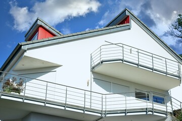 Moderner Balkon mit Edelstahl-Sichtschutz und Edelstahl-Geländer an einer Neubau-Hausfront