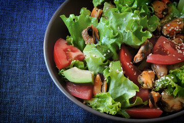 Healthy salad with avocado and mussels. Diet food. Keto salad.