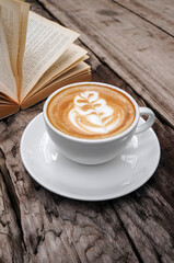 Close up hot cappuccino white coffee cup with heart shape latte art on dark brown old wood table at caff food and drink concept