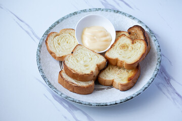 Toasts in a plate with cheese on a gray background