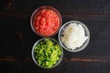 Bowls of Pureed Vegetables on a Wood Table: Pureed onions, tomatoes, green chili peppers, ginger, and garlic