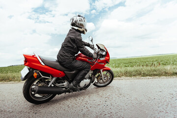 Obraz na płótnie Canvas Motorcyclist makes a U-turn on a motorcycle