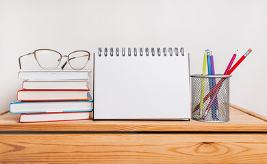 white notepad, books, glasses and pensil on workplace. Mock up in copy space office purple background. It is important not to forget the note
