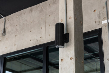 black lamps on concrete pole in front of house.
