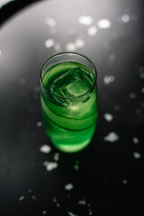 Green cocktail with cucumber and ice.