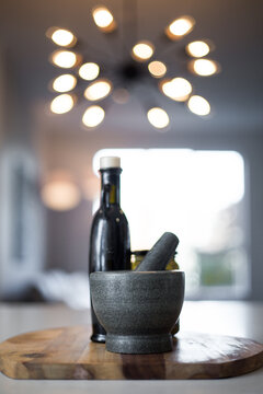 Vertical Shot Of A Glass Bottle And A Mortar And Pestle On A Table