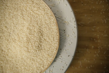 white rice Thai in a white round plate on a wooden background. Selective focus