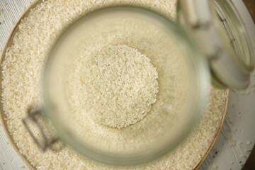 white rice Thai in a white round jar on a wooden background. Selective focus
