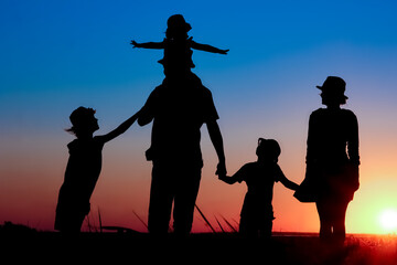 A Happy family by the sea at sunset in travel silhouette in nature