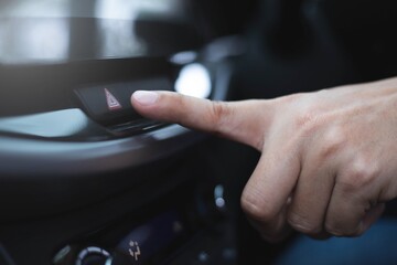 Image of hand press the emergency inside the car.Safety transportation concept.