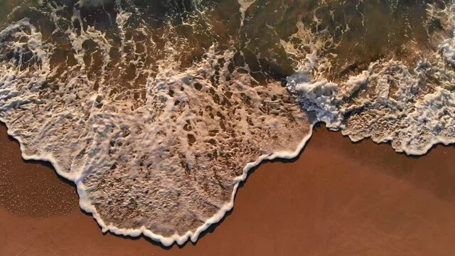 shot from footprints in the sand to surf on the shore of Miami Beach
