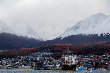 Fototapeta na wymiar City among snow mountains and a cargo ship