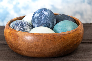 Blue colored eggs in wooden bowl