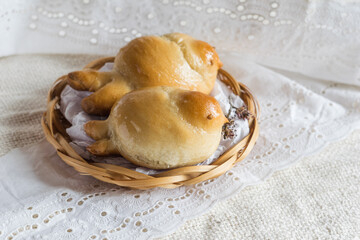 Two easter bird-shaped lean buns coated with sweet syrup on a plate on light textile, selective focus, rustic style.